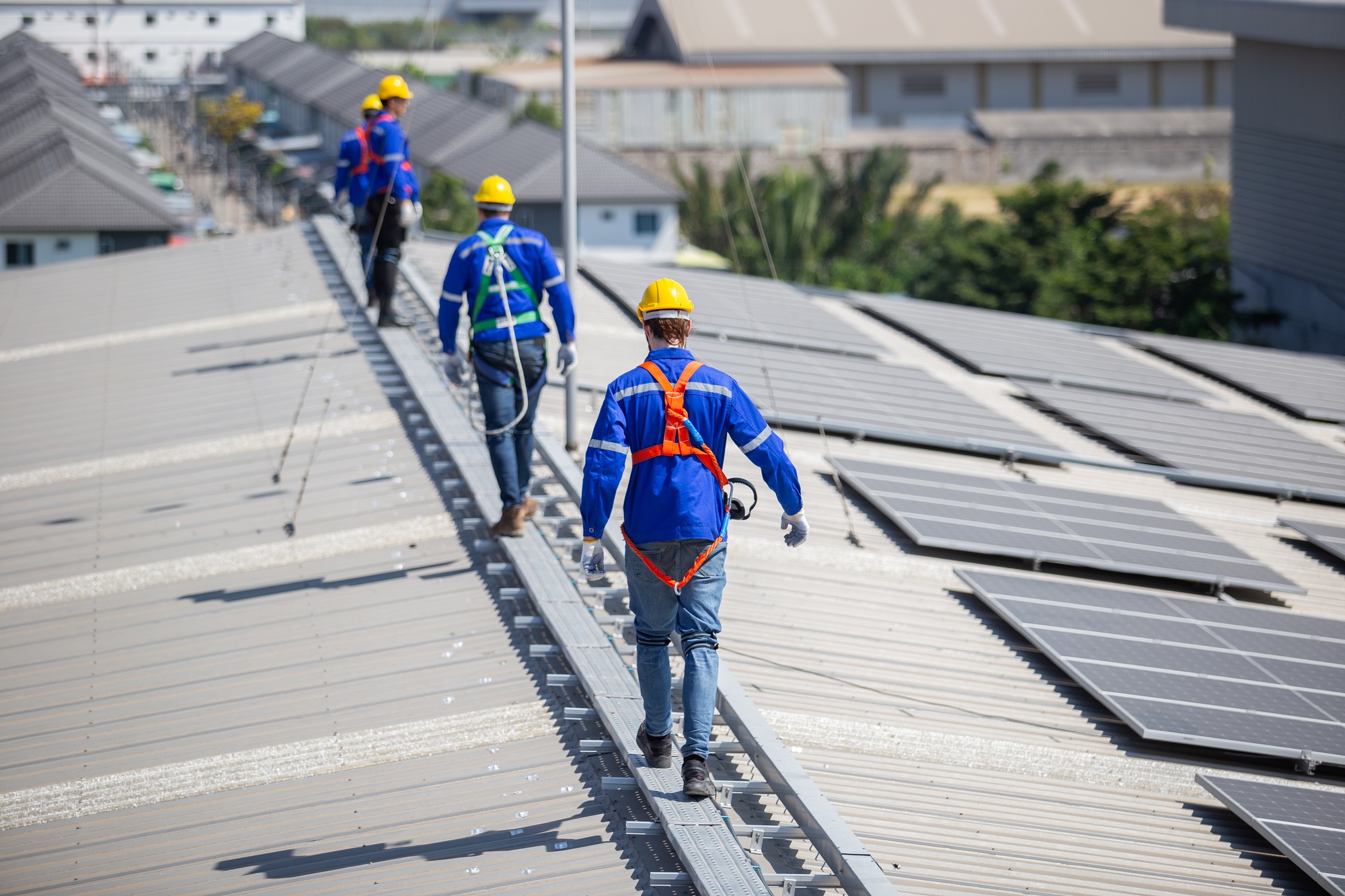 Technicians are installation and inspection standards of solar panels on roof of an industrial facto
